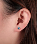 Skip The Itch With These Implant Grade G23 Titanium Screw Back Earrings Featuring Hypoallergenic Design And F136 Certified For Totally Sensitive Tolerant Ears While Delivering Premium Nickel Free Security And Long Lasting Wear Without Any Drama Or Redness, showcasing aqua CZ stone on ear.
