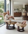 Man relaxing on Swivel Recliner With Ottoman And Wood Base In PU Leather Ultra Plush Double Foam For Cozy Comfort Footrest 360 Degree