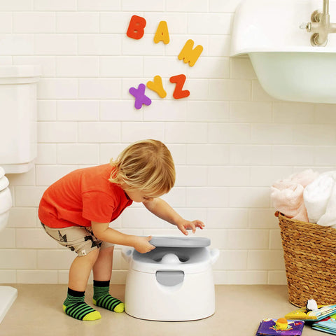 A toddler interacting with The Real Deal Toddler Potty Training Chair 3-In-1 Potty Seat With Step Stool Plus Arm And Hammer Deodorizing Disc Gray.