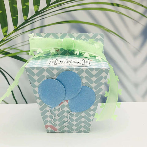 Gift box made with the Milk Box Gift Box Die Cut Set For Paper Craft And Scrapbooking, decorated with blue balloons and green ribbon.