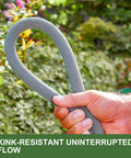 Close-up of gray fabric-covered garden hose held in a hand; kink-resistant for outdoor watering.