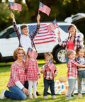 Family holding Pack Of 12 Small 8x12 Inch American Flags On Sticks With Kid Safe Spear Tops For Memorial Day Fourth Of July celebration