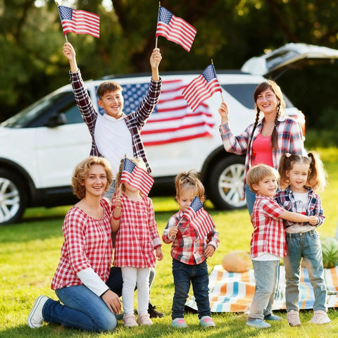 Family holding Pack Of 12 Small 8x12 Inch American Flags On Sticks With Kid Safe Spear Tops For Memorial Day Fourth Of July celebration