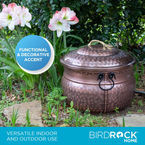 Water Hose Holder With Lid Ground Garden Hose Pot For Indoor And Outdoor Use Copper Accents Steel Construction With Handle Decorates Patio Or Deck Keeps Hose Neat Protected And Ready To Go, placed among flowers outdoors.