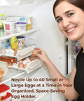 Person placing eggs in an Egg Holder For Refrigerator With 40 Egg Capacity Two Tray Plastic Design Includes Time Tracker Brush And Nonslip Lid Top No Fuss To Stack And Organize Your Fridge.