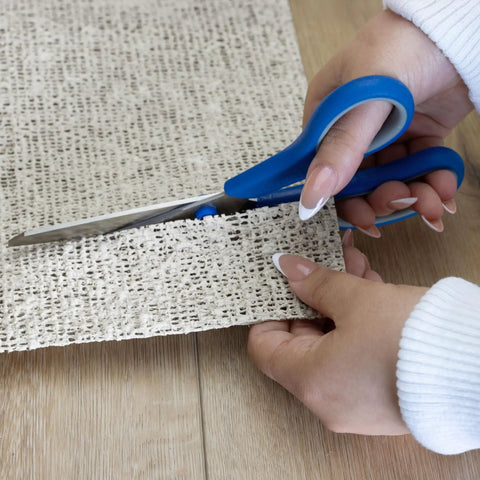 Hands cutting Nature's Grip Stays Put Non Slip Rug Pad 2x6 Feet 1/16 Inch Thick Rubber and Jute Eco Friendly Underlayment to size