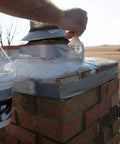 Person applying Bone Dry Chimney Crown Sealer Brushable Elastomeric Waterproof Membrane on brick chimney top.