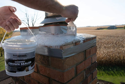 Person applying Bone Dry Chimney Crown Sealer Brushable Elastomeric Waterproof Membrane on brick chimney top.