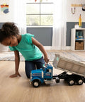 Child playing with Blue Peterbilt 1/16 Scale Dump Truck Toy With Working Dump Bed 20 Inch Construction Vehicle indoor