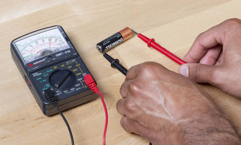 GMT 318 Analog Multimeter With Six Functions And Fourteen Ranges testing battery with color coded dial and test leads