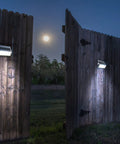 Upgrade Solar Step Lights 12 Pack Outdoor LED Deck Lights With Side Button Design illuminating wooden fence at night