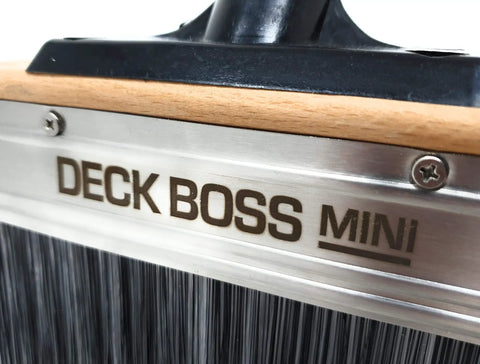 Close-up of Deck Boss Mini 6 Inch Deck Stain Brush Applicator with visible logo and metal frame for wood, concrete, fences, and siding.