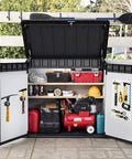 Outdoor storage shed with assorted tools and equipment, open doors displaying shelves and hooks on the doors.