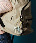 Heavy-Duty Brass Key Ring Clip Set 4 Pcs 3.35in Screw Lock Keychain Carabiner Holders attached to a beige backpack