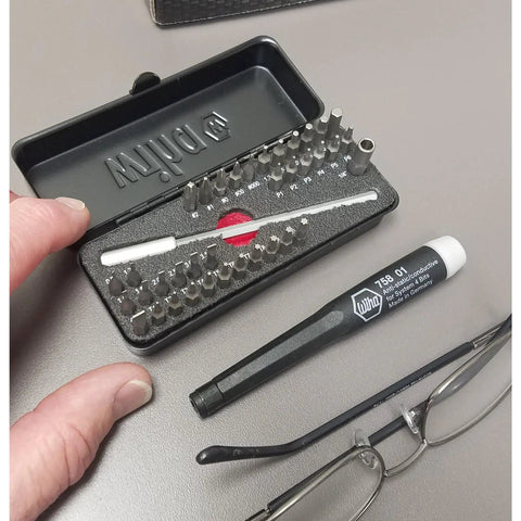 All In One ESD Safe Go Box Micro Bits Set With 39 Pieces Including Slotted Phillips Hex Torx Pentalobe Bits Micro Bit Handle And 100mm Extension Built For Fast Electronics Repairs And Precision Work, shown open on table with lenses.