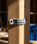 Killer Grip 20 Pack PVC Pipe Clamps Half Inch Conduit Straps mounted on a wooden post for secure wire routing.