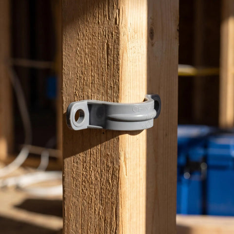 Killer Grip 20 Pack PVC Pipe Clamps Half Inch Conduit Straps mounted on a wooden post for secure wire routing.