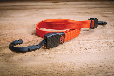 36 Inch Flat Bungee Straps 2 Pack With Coated Steel Hooks And Easy Grip Pad Black And Orange laying on wood surface