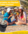 3-In-1 Resin Ice Bucket And Beverage Cooler Table For Outdoors With Lift Top Lid Wood-Look Side Table UV Protected And Drain Plug Party-Ready Poolside Patio Bar Entertaining Dark Black shown on a beach with group of people enjoying drinks.