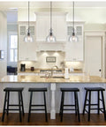 Two Pack One Light Adjustable Mini Pendant With Hand Blown Clear Seeded Glass In Oil Rubbed Bronze Finish over a kitchen island.