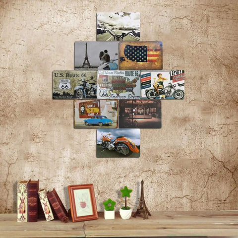 Assorted vintage travel and motorcycle themed posters displayed on a rustic wall above a shelf with books and decor items.