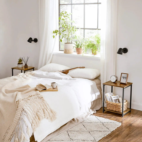 Bedroom scene with set of two industrial style end tables with rustic brown tops and matte black steel frames beside the bed.