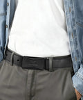 Man wearing TSA Approved Nickel Free Hypoallergenic Plastic Belt With No Metal Buckle For Men Black Leather Look Breeze Through Airport Security Scratch Resistant Comfortable Fit Belt That Wont Dig In Or Cause Allergies with jeans and white shirt.