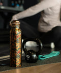 Copper Water Bottle 1 Liter With Ayurvedic Health Benefits beside gym equipment and person stretching.