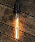 Dimmable T10 Amber LED Tubular Bulb 6W 60W Equivalent, Retro Edison Style Light; warm glow on rustic wooden surface