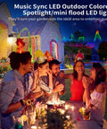 Group enjoying a party with Smart Outdoor Halloween Lights 15W RGB Flood Spotlight With US Plug around a garden table.