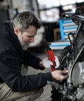 Mechanic using Cordless Ratchet Wrench Three Eighths Inch Delivers 44.25 Foot Pounds Of Torque At 380 RPM on motorcycle