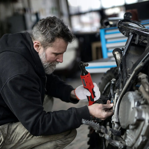 Mechanic using Cordless Ratchet Wrench Three Eighths Inch Delivers 44.25 Foot Pounds Of Torque At 380 RPM on motorcycle