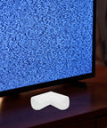 12 Pack EPE Foam Corner Protectors for Picture Frames Mirrors TVs and Electronics Cushions Edges During Shipping and Moving Provides Safe No Residue Edge Protection for Fragile Goods White placed in front of a TV screen.