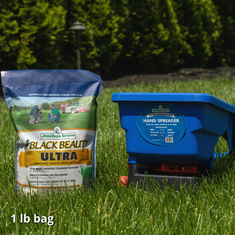Handheld Lawn Spreader For Seed And Fertilizer, Easy Crank Broadcast Spreader in blue next to Black Beauty Ultra seed bag on grass