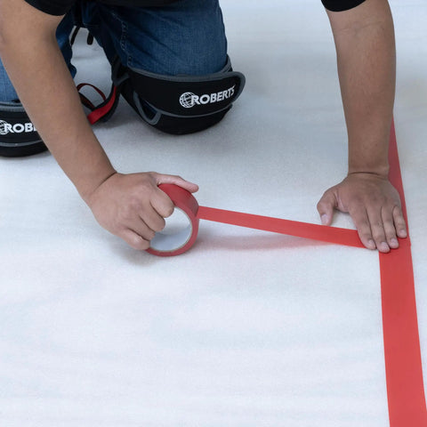 No Nonsense Foam Underlayment Roll Quiet Room Padding for Laminate being installed with red tape on foam surface.