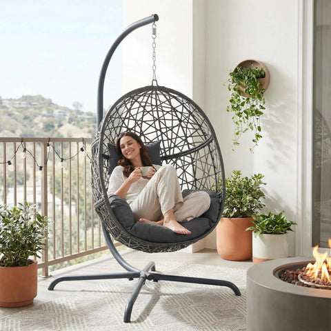 Swing Egg Chair With Stand Bird Cage Patio Hanging Chair With Cushions For Indoor Outdoor Use All Weather 350 Lb Capacity Big Dark Grey on balcony with woman relaxing