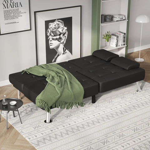 Futon Sofa Bed Convertible Lounge With Adjustable Back Three Positions 120 160 180 Degrees Removable Armrests Two Cup Holders PU Leather Black in a Cozy Living Room Sleep Solution setup as a bed with a green blanket.