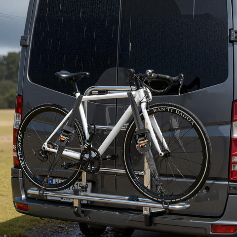 Bicycle mounted on a vehicle rack during rain, secured with Two Pack Retractable Ratchet Straps 2 Inch By 10 Foot Tie Down Straps