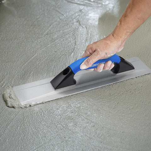 Hand using Pro Grade Cast Magnesium Concrete Hand Float With Ergonomic Rubber Handle 16 By 3 And A Half Inches Widened Beveled End For Smooth Finishes Curved Base Mag Trowel on wet concrete surface.