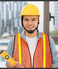 Man wearing Neon Orange 20 Pack High Visibility Reflective Safety Vest with Lightweight Mesh and yellow hard hat at construction site.