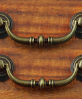 Antique Drop Bail Drawer Pulls 4.5 Inch Long 88mm Center To Center 3.5 Inch Vintage Bronze Cabinet Pull Handles on wood surface
