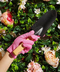 Person wearing pink Women's Garden Gloves Set, 6 Pairs, Thorn Proof And Cut Resistant, Breathable Cotton With Enhanced Grip holding trowel.