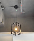 Industrial Black Pendant Light Fixture With Geometric Wire Cage hanging from ceiling, showcases modern loft vibe