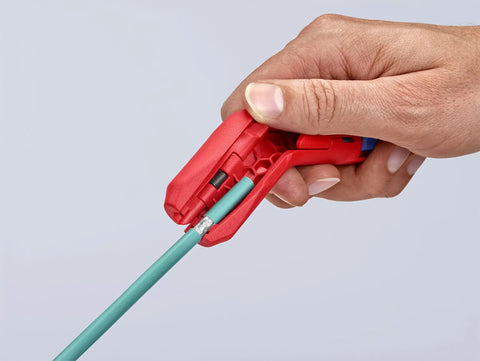 Hand using Workhorse Ergostrip Cable Stripping Tool with ergonomic pistol grip, stripping a round damp-proof cable