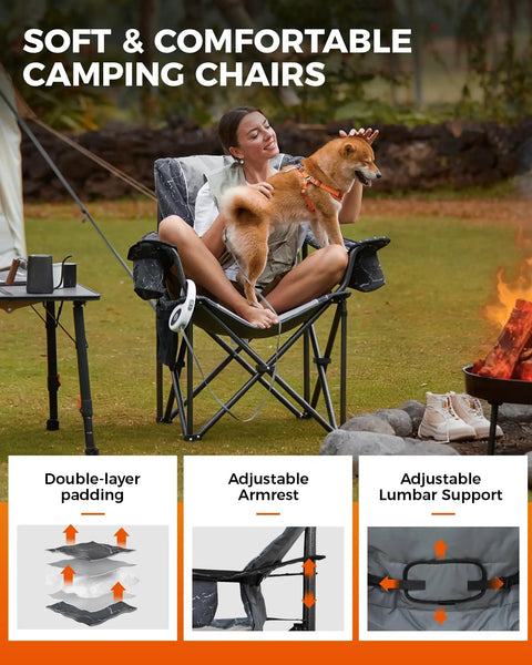 Woman sitting in oversized camping chair with adjustable lumbar support, featuring dog on lap, near campfire and outdoor setting.