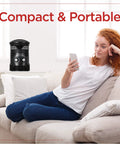 Compact 360 Degree Surround Desk Heater And Fan for Office and Home Use displayed on a couch with a person using a smartphone.