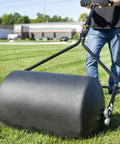 Person using Spyker 300lb Push Tow Commercial Lawn Roller With No Tools Handle on grass