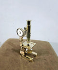 Top Shelf Handmade Solid Brass Microscope With Adjustable Focus Knob Straight Fire Vintage Desktop Display on brown leather surface.