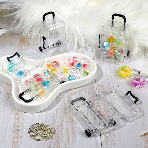 Front view: transparent plastic mini luggage storage boxes with black handles and wheels; 12-piece set