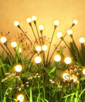 Solar Garden Lights Outdoor 2 Pack 16 LED Firefly String Lights Waterproof glowing in garden with plants and flowers at night